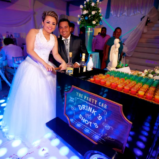 Pareja posando junto a la barra de cocteles de su inolvidable noche de bodas