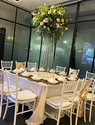 Mesa para invitados adornada con un bello centro de mesa